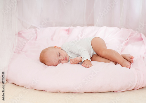 Beautiful sleeping baby. Peaceful baby lying on a bed in a brigh