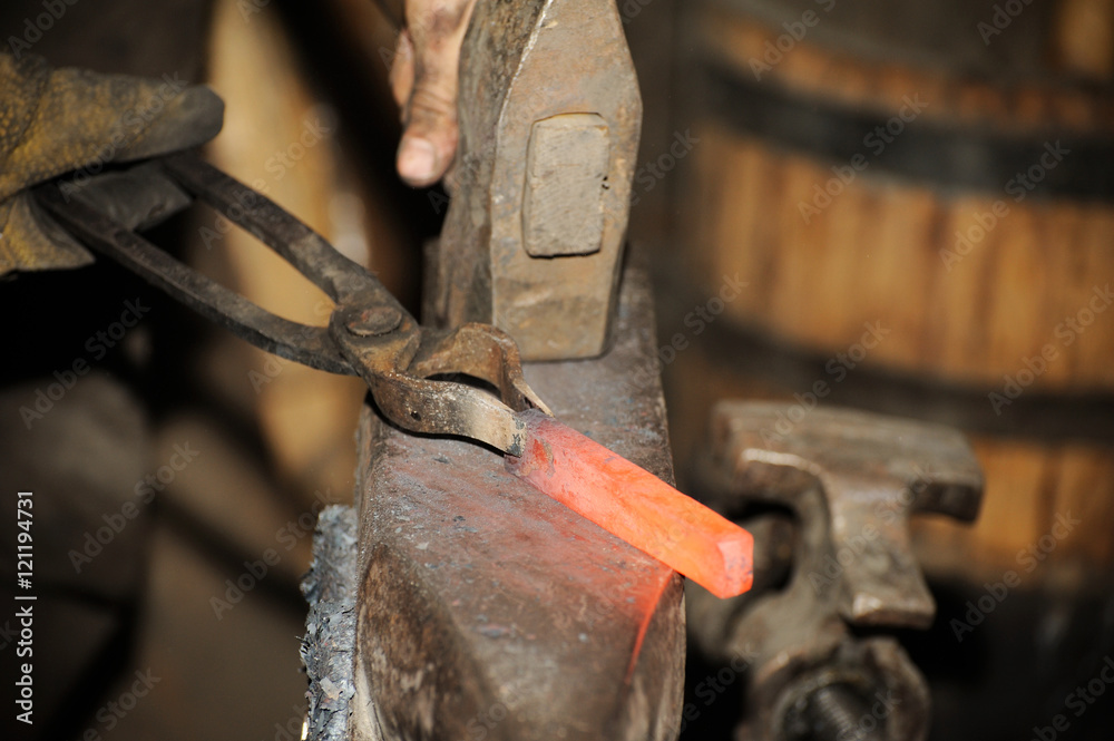 Blacksmith working in the forge processes the metal . Blacksmith working in the forge processes the metal .