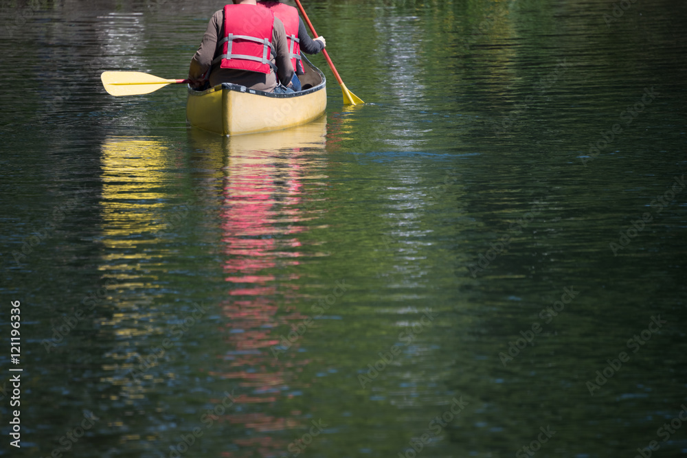 Canoeing on Green Lake. Canoeists in Life Jackets. Reflections of Canoe. Copy space. Canoeing on Green Lake. Canoeists in Life Jackets. Reflections of Canoe. Copy space.