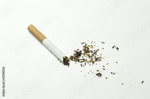 Broken cigarette with splashed tobaccoo. On white background