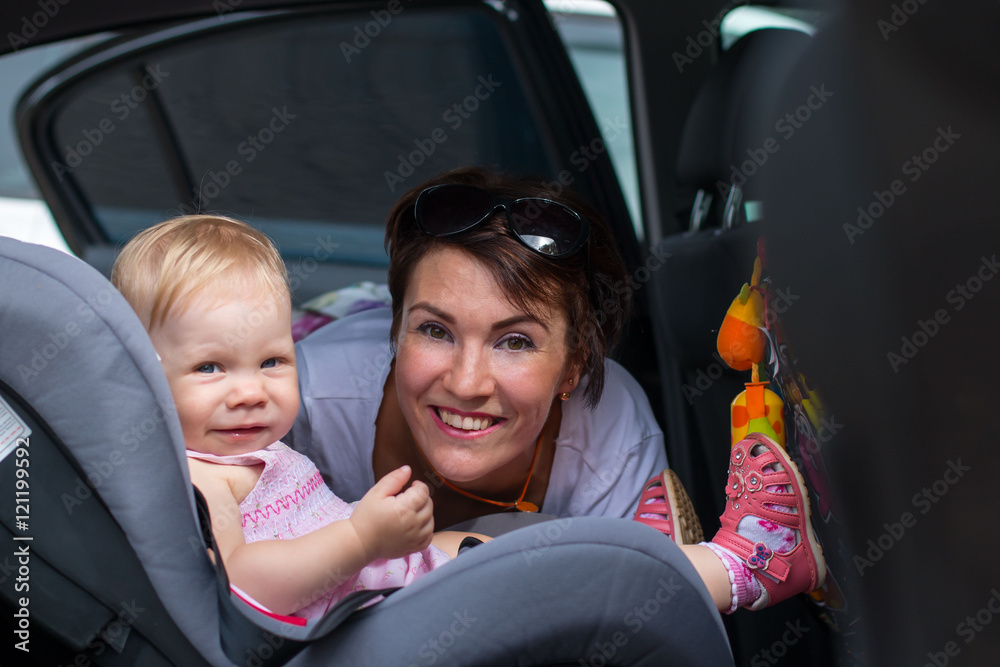 Nice girl and small baby in the car