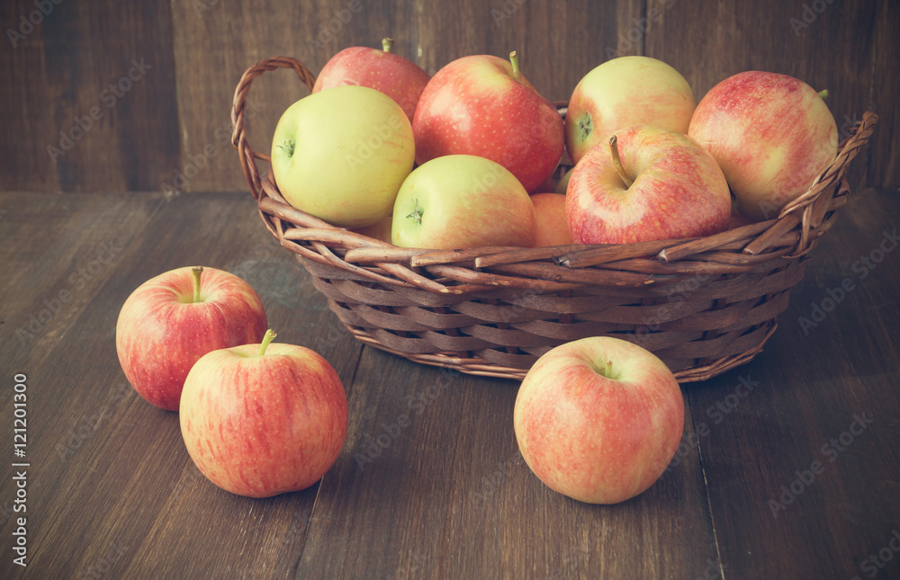 Apples in basket on wooden rustic background