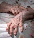 Old woman applying hand cream