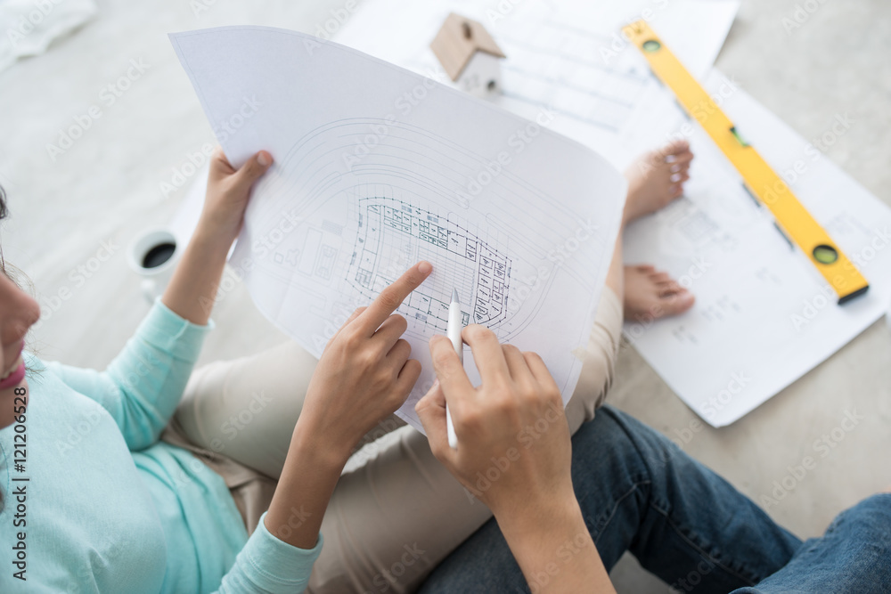 Cheerful asian couple looking at construction house plan Cheerful asian couple looking at construction house plan