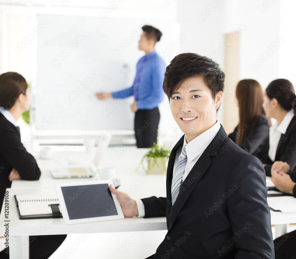 Smiling businessman looking at camera with colleague Smiling businessman looking at camera with colleague