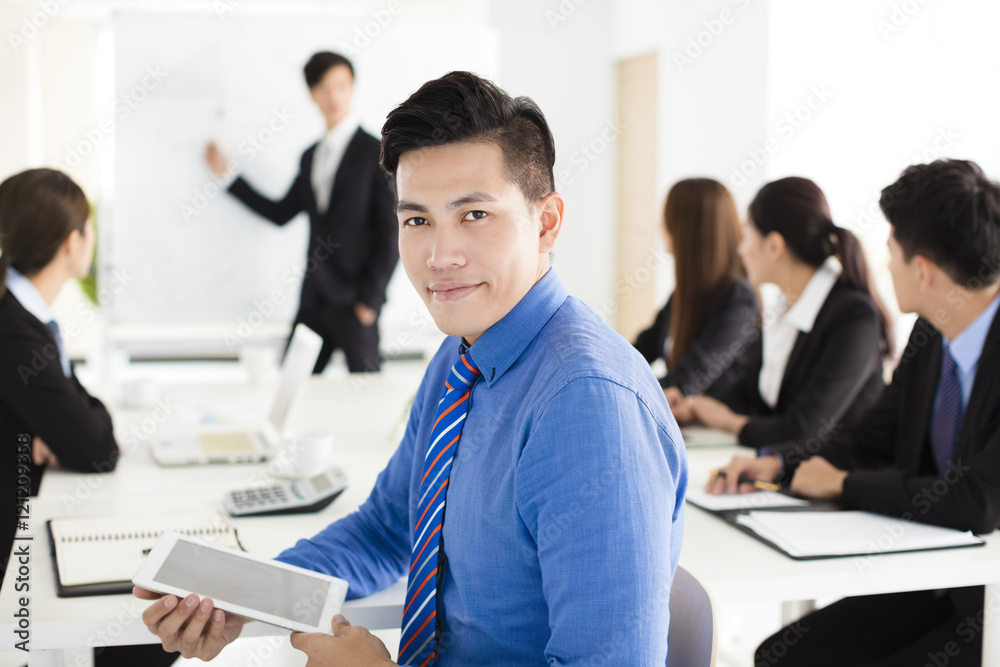 Smiling businessman looking at camera with colleague Smiling businessman looking at camera with colleague