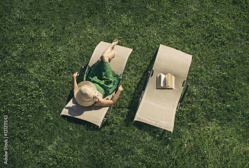Papier peint woman in the green dress lying on a sunbed with book