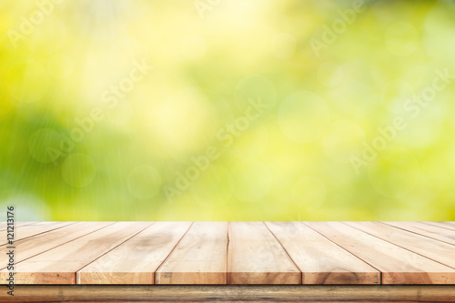 Empty wooden  table with foliage bokeh background. Ready for product display montage.
