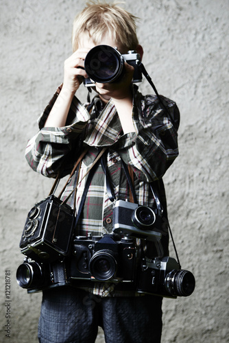 Child boy photographer with many cameras around his neck. photo