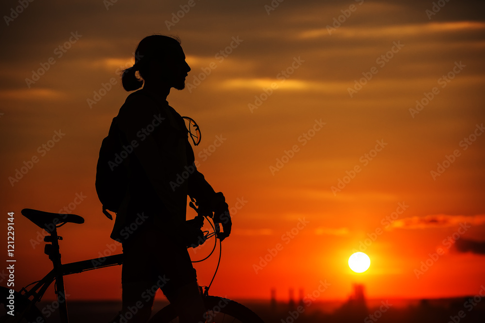 Silhouette of a bike on sky background during sunset