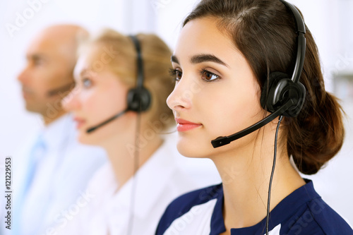 Call center. Focus on beautiful woman in headset