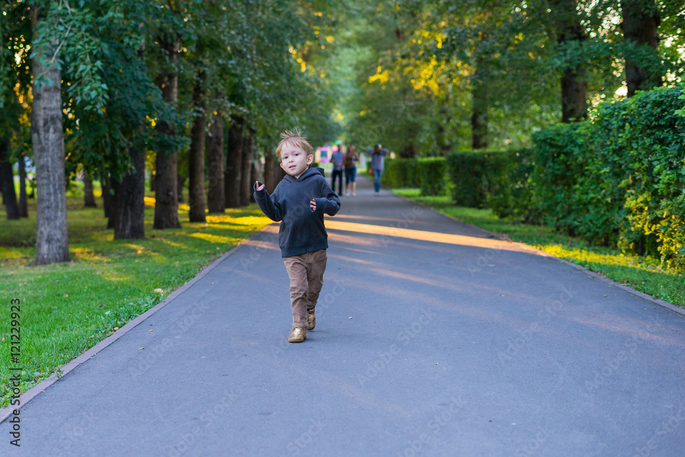 Boy running on the road in the park Boy running on the road in the park