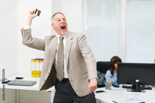 Angry businessman throwing away his phone photo