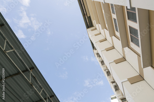Apartment housing seen from below. Look up building with clear sky background.