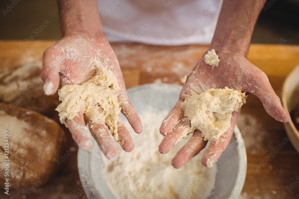 Hands of baker mixing flour by hand