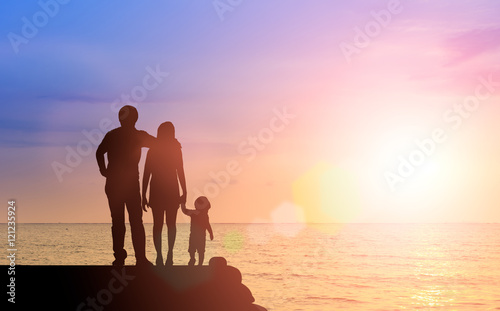 lhouette happy family together, father, mother with little boy or child stay nearly beach or sea during sunset. happy family at beach sunset having happy feeling. love family concept take care rest.