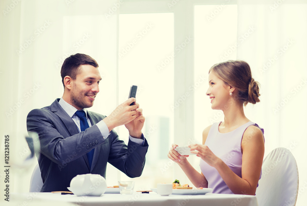 smiling couple with sushi and smartphones smiling couple with sushi and smartphones