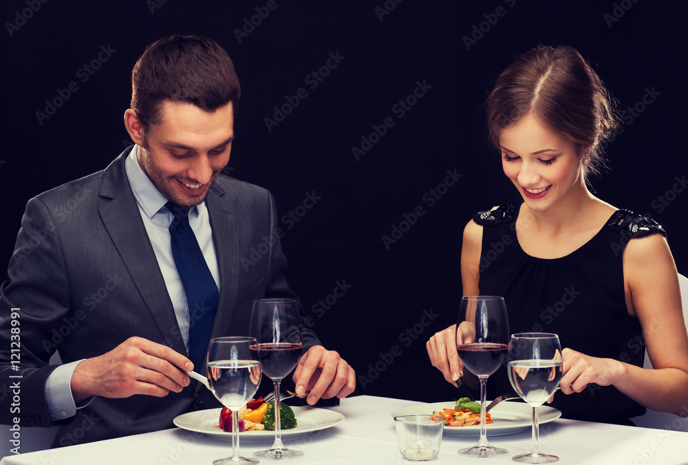 smiling couple eating main course at restaurant smiling couple eating main course at restaurant