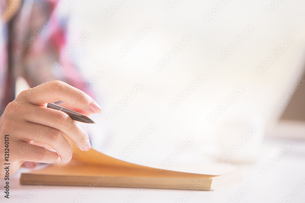 Female hand writing in notepad Female hand writing in notepad