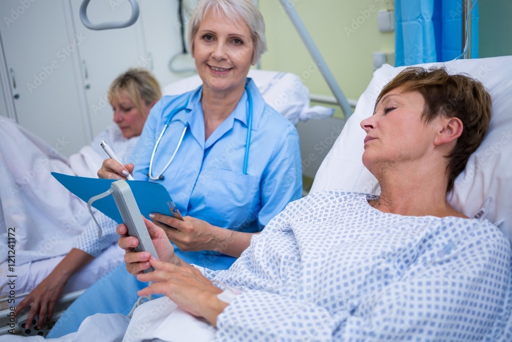 Patient using medical device and nurse sitting Patient using medical device and nurse sitting