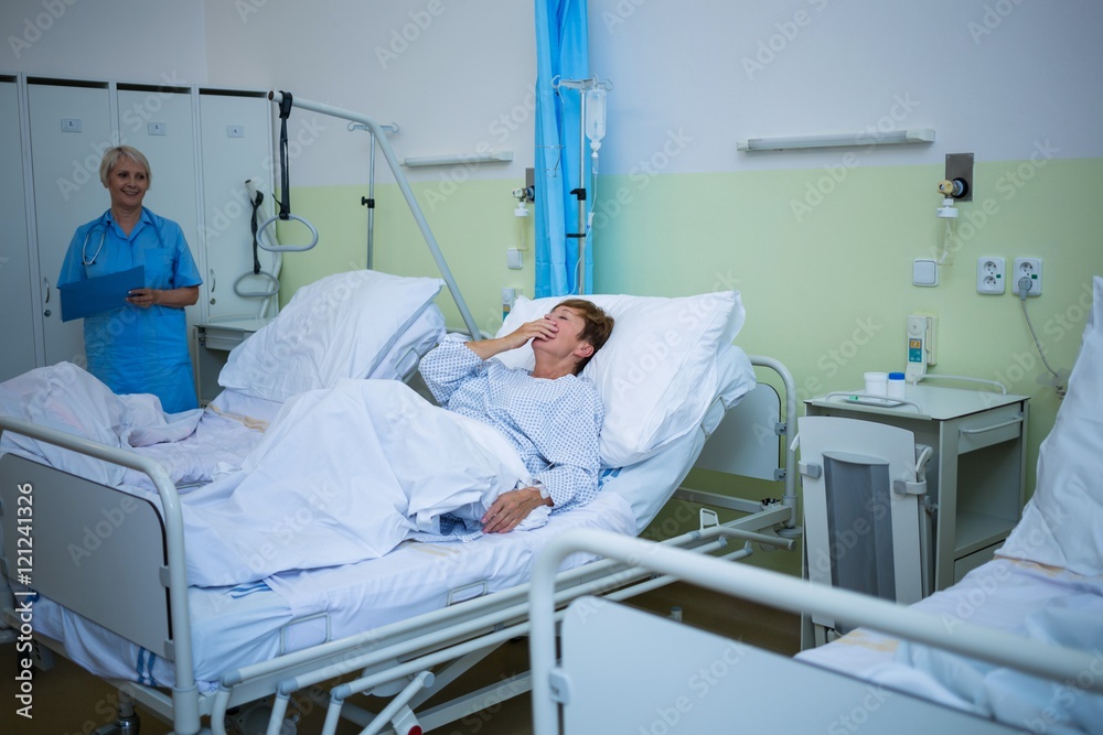 Senior patient laughing while lying on a bed Senior patient laughing while lying on a bed