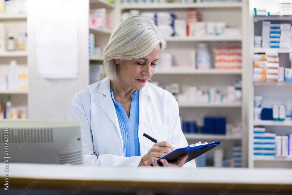 Pharmacist writing on clipboard Pharmacist writing on clipboard