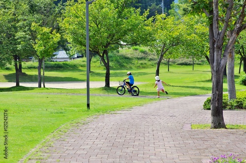 夏の公園で自転車に乗る少年