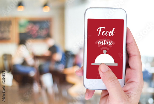 Smart phone with food online device on screen over blur restaura