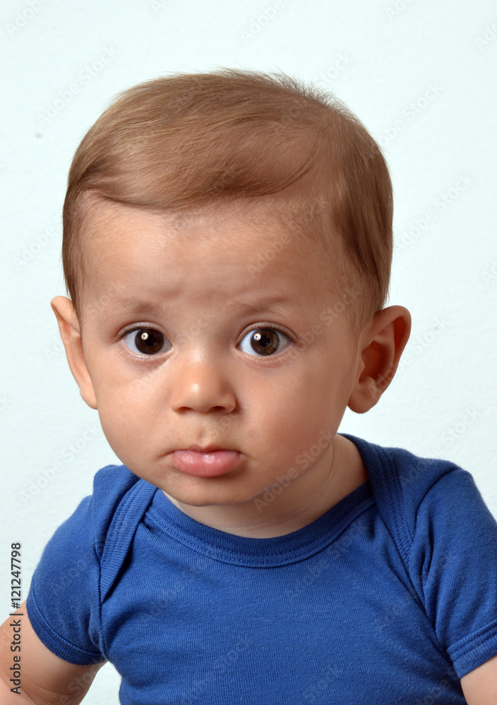 Retrato de un hermoso bebe rubio con camisa azul en fondo blanco Retrato de un hermoso bebe rubio con camisa azul en fondo blanco