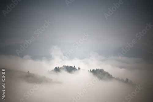 Autumn foggy mountain scene. Fall rain and mist