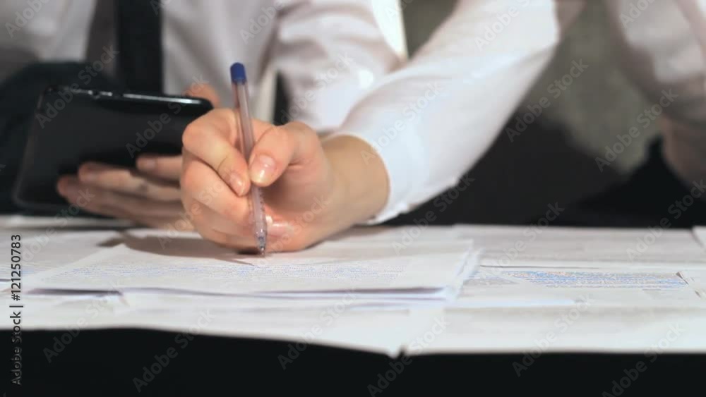 Businessman signs a document at work Businessman signs a document at work