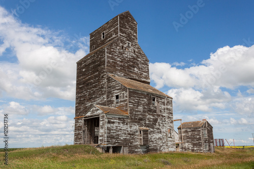 Old Weathered Grain Elevator with Blue Sky and Clouds