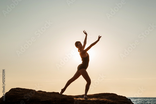 Wallpaper Mural Beautiful ballerina dancing, posing on rock at beach, sea background. Torontodigital.ca