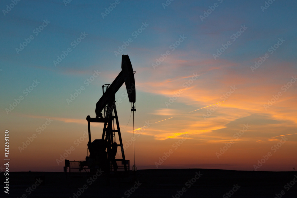 Oil Well Silhouetted Against Prairie Sunset