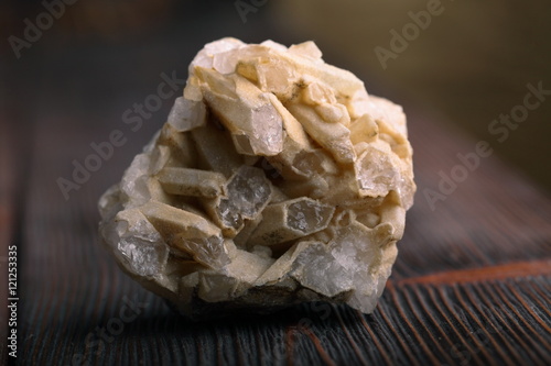Rock crystal mineral stone on the wooden background. Quartz variety.