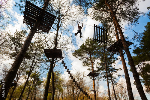 Boy climbing in a rope park photo