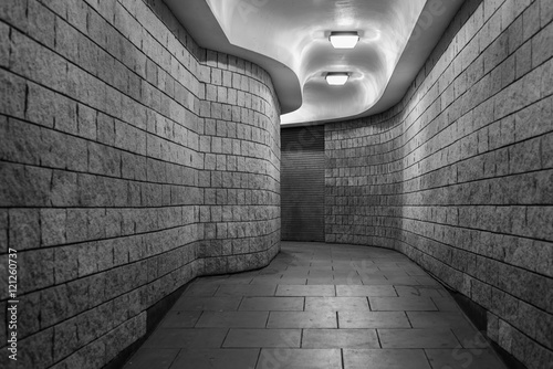 a curving pedestrian tunnel (subway) in the City of London, at night - black and white