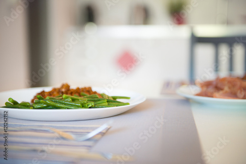 Side of fresh lightly cooked organic green beans on dinner plate