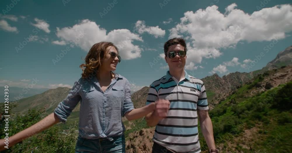 Success, achievement and accomplishment concept with young couples cheering jumping, celebrating of joy on trekking hike outside.