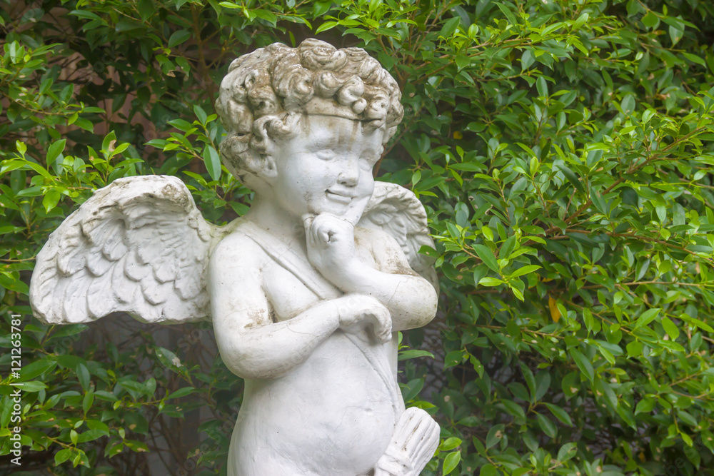 Cupid statue in the garden with leaf background Cupid statue in the garden with leaf background