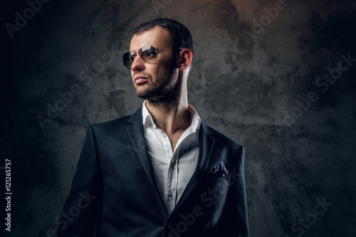 Portrait of male in sunglasses and grey business jacket.