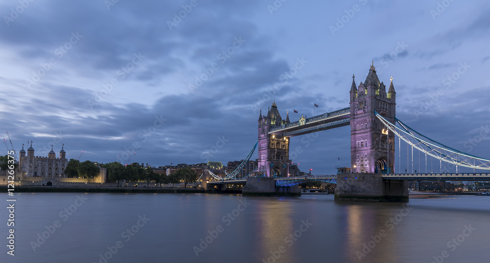 Obraz premium Tower Bridge, London, at sunset, with the river Thames in the foreground and the Tower of London across the river.