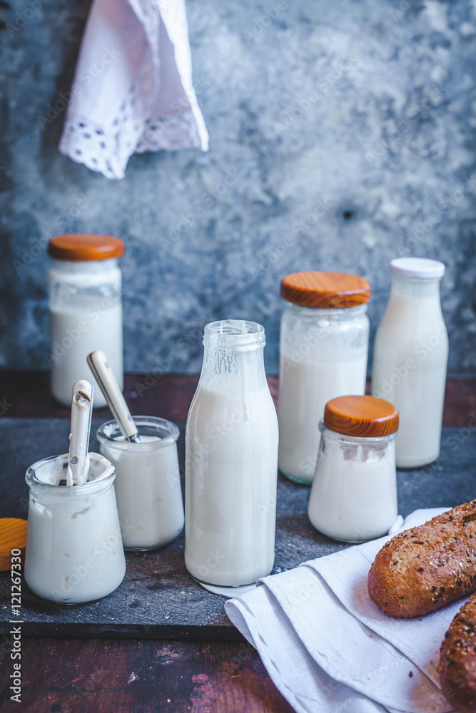 Natural yogurt and milk kefir on a rustic table. - obrazy, fototapety, plakaty 