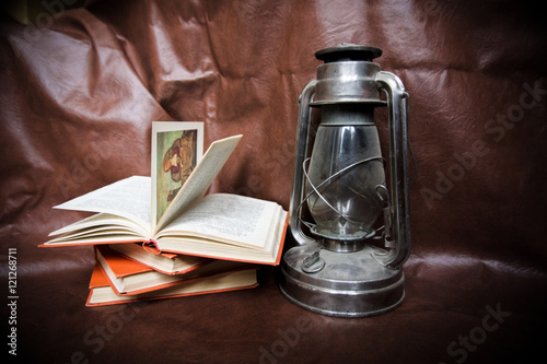 kerosene lamp and books on a brown background