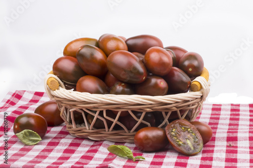 bunch of dark ripe juicy garden tomato in a basket