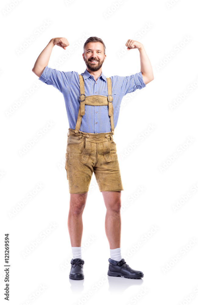 Man in traditional bavarian clothes showing biceps on his arms Man in traditional bavarian clothes showing biceps on his arms