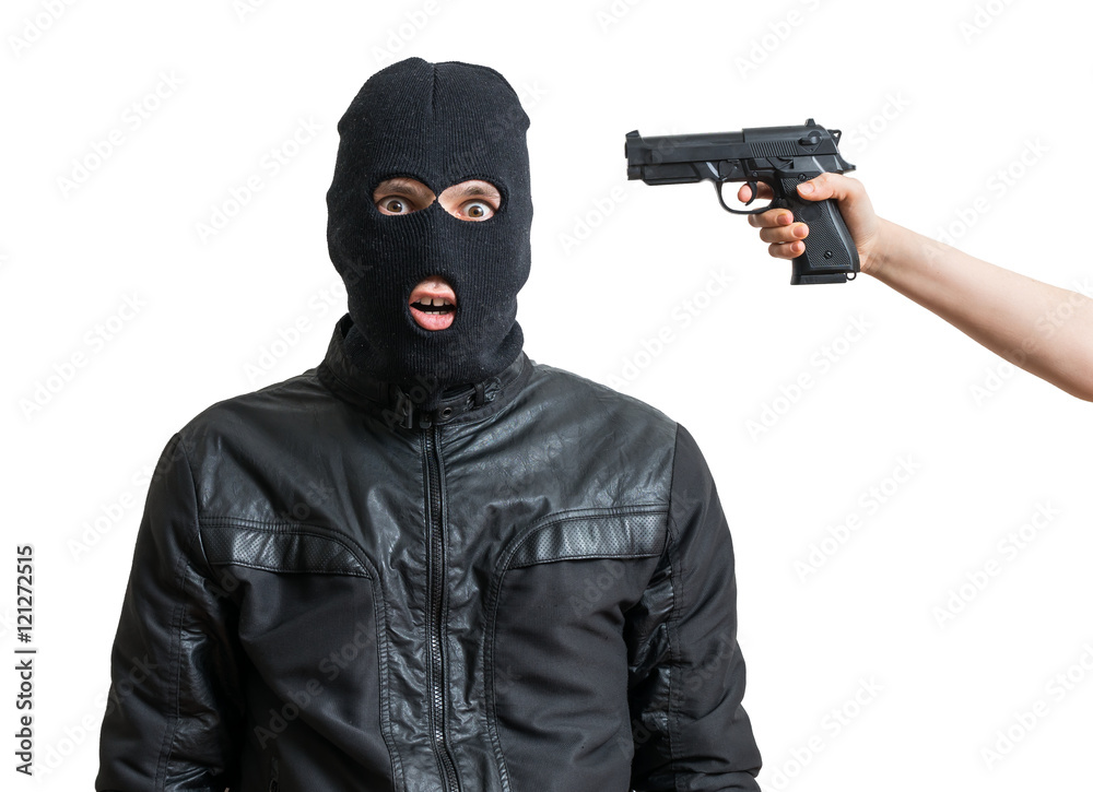 Arrested burglar or robber isolated on white background. Hand is aiming with pistol on thiefs head.