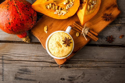 Pumpkin mug-cakes in rustic style, on an old wooden table, next to the cuted pumpkins and spices, close view, copy space photo