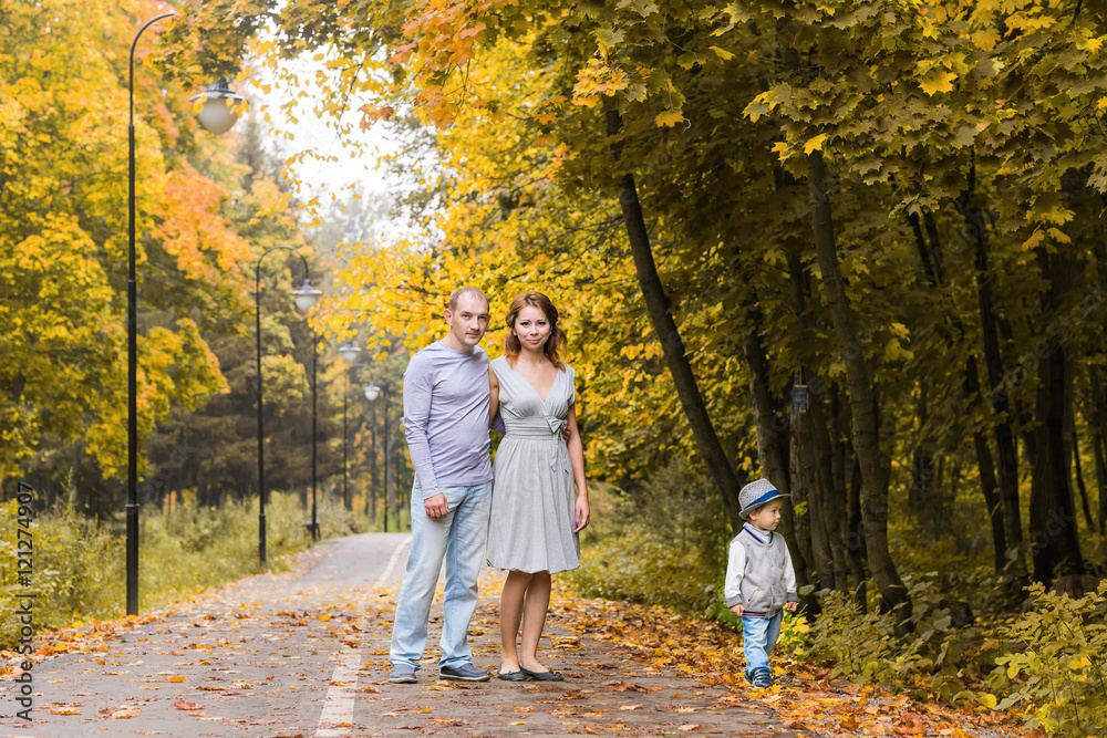 friendly family walking in the park in autumn together friendly family walking in the park in autumn together