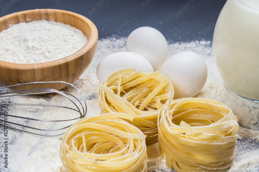 Eggs, flour and fettuccine on a gray background Eggs, flour and fettuccine on a gray background